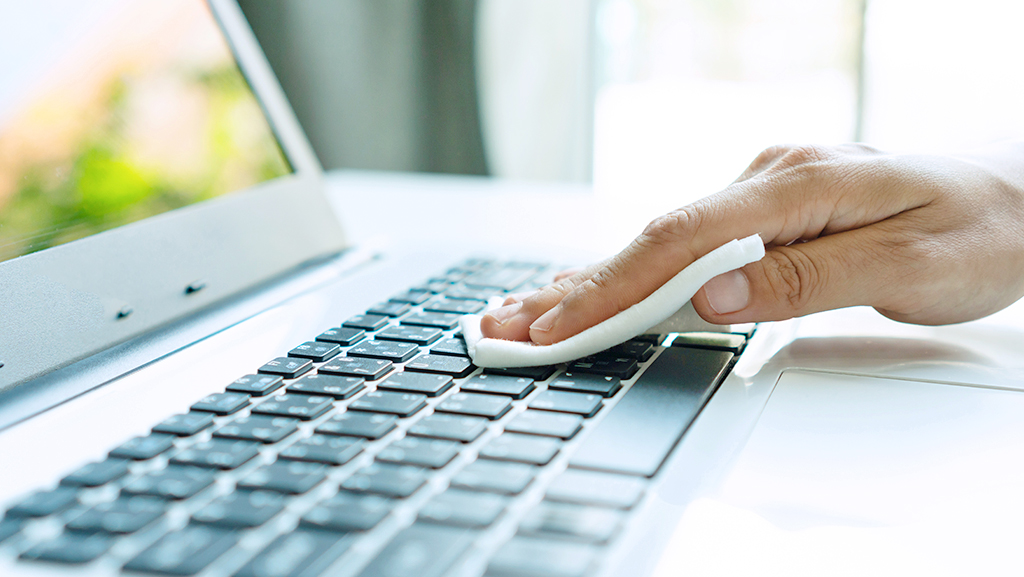 Cleaning laptop keyboard with microfiber cloth