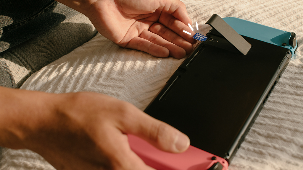 Person inserts an SD card into a Nintendo Switch